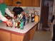 1988 Ford Bronco - A collection of alcoholic beverages and mixers are laid out on a kitchen counter, with several people present.