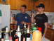 1988 Ford Bronco - Two men are in a kitchen, one holding a camcorder and the other holding a drink, surrounded by bottles of alcohol.