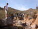 1984 Ford Bronco - A group of people stand on rocks in a desert canyon, with a cactus visible in the background.