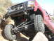 1984 Ford Bronco - This red SUV is equipped for off-road terrain, with large tires and a reinforced front bumper.