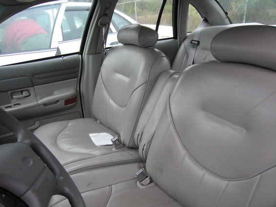 Interior shot of a car showing front and back seats, with another car visible through the window