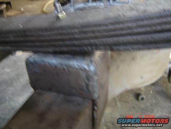 Close-up of a welded leaf spring mount on a vehicle's suspension