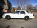 2000 Ford Crown Victoria - A white 2000 Ford Crown Victoria sedan is parked in a driveway on a sunny day.