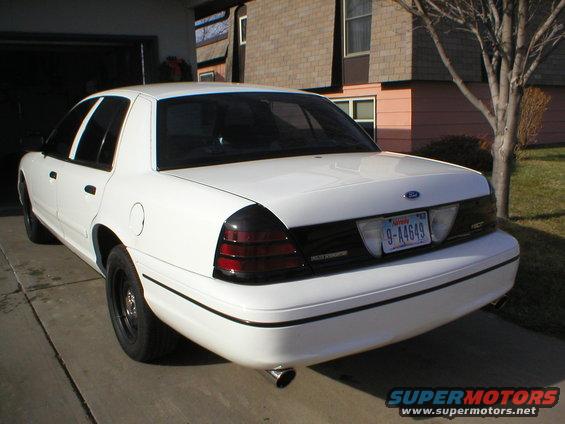 White 2000 Ford Crown Victoria parked in driveway, rear view. License plate 9-A4649