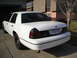 2000 Ford Crown Victoria - Rear view of a white 2000 Ford Crown Victoria with a black trim panel and tinted taillights.