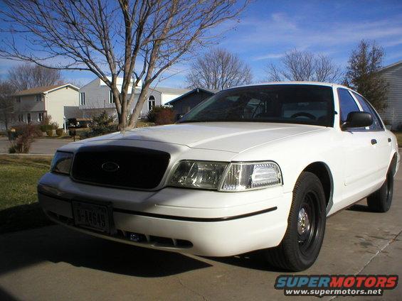 White 2000 Ford Crown Victoria, front 3/4 view, parked in driveway, clear sky