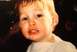 1999 Ford Taurus - A young child with blonde hair and wide eyes appears upset in this close-up photograph.