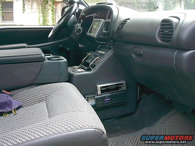 Interior of a truck, showing the center console, dashboard, and passenger seat. Has an aftermarket stereo and GPS mount