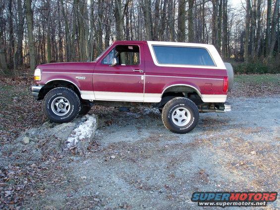 Maroon and white 1993 Ford Bronco driving off-road