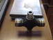 1969 Ford Bronco - A universal joint part is shown on a table next to some DVDs.