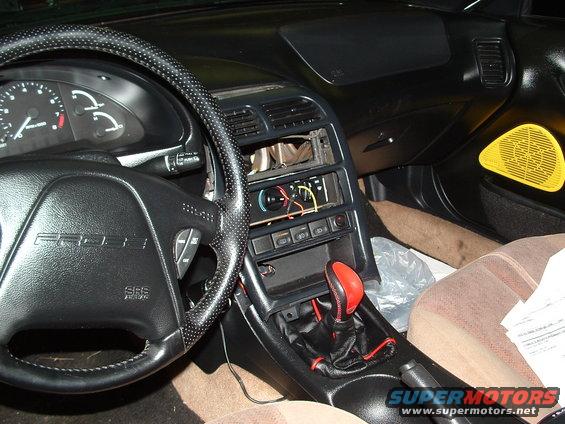 Driver's side interior of a 1996 Ford Probe, showing the steering wheel, dashboard, center console with gear shifter, and passenger seat