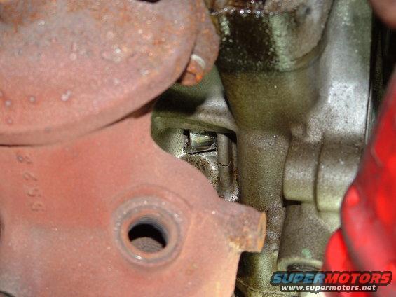 Close-up of a rusty engine component with stamped numbers '8655'