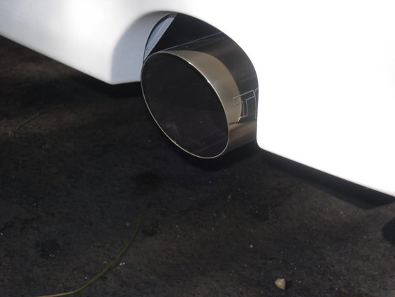 close-up of a car's exhaust pipe with a 'TT' logo etched on it