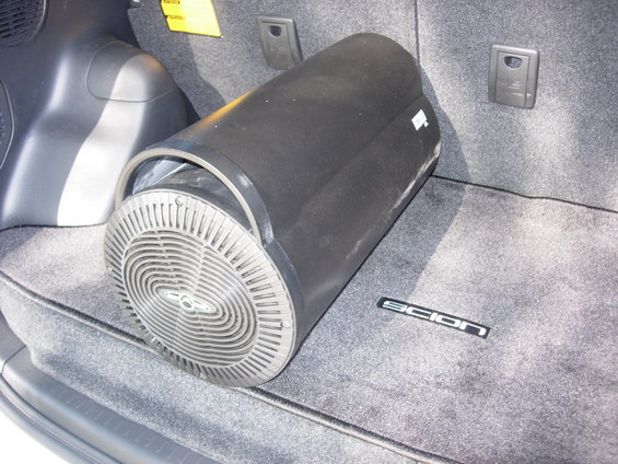Subwoofer in the trunk of a car. Scion logo visible on the carpet