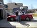 1996 Ford Probe - A red convertible sports car is parked in a driveway with a white SUV behind it and two people standing next to the car.