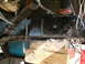 1979 Ford Bronco - Close-up view of vehicle undercarriage components, including frame and suspension, supported by wooden blocks.