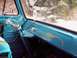 1963 Ford E100 - The interior of a blue 1963 Ford E100 van features a unique chain-wrapped steering wheel and custom pinstriping on the dashboard.