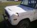 1974 Ford Bronco - A white 1974 Ford Bronco is shown from the front passenger side, with visible rust and wear.