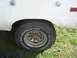1974 Ford Bronco - Close-up of a white vehicle's rear wheel and fender, showing a BFGoodrich tire.