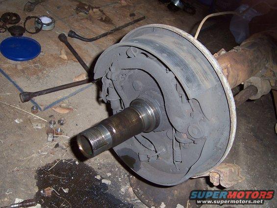 Rear axle drum brake assembly with tools on concrete floor