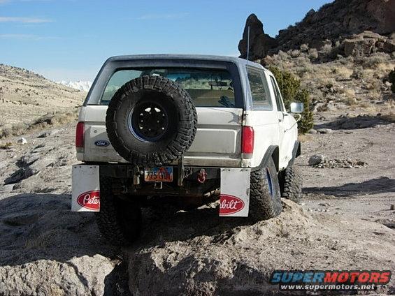 White 1987 Ford Bronco rear view with spare tire on back, off-roading