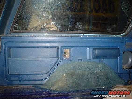 Blue interior panel with storage compartment and speaker. Text 'SIZE LOAD' visible through window
