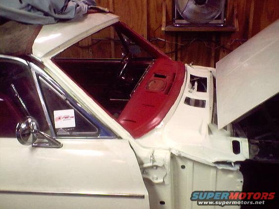 White 1966 Ford Fairlane interior and fender, showing red dashboard and chrome mirror