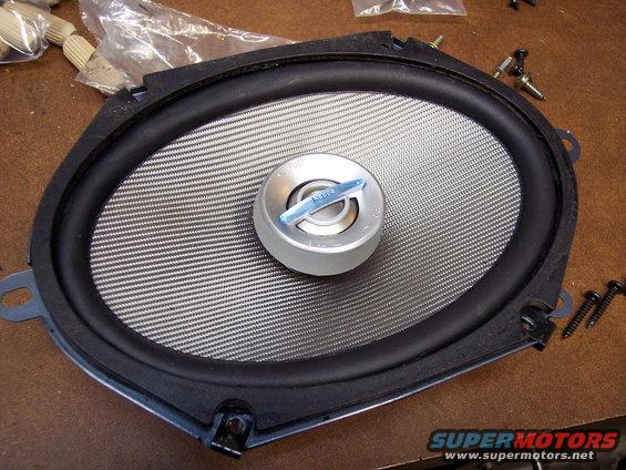 Car speaker with silver cone and blue tweeter. Screws are visible nearby