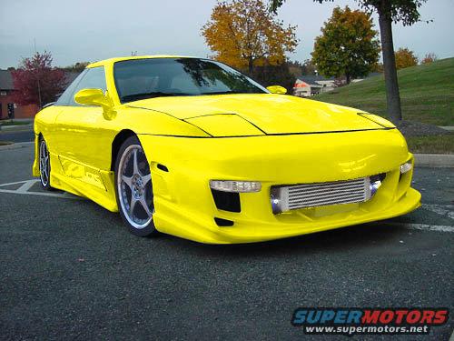 Yellow 1994 Ford Probe with custom body kit and front-mounted intercooler parked on asphalt