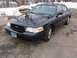 1999 Ford Crown Victoria - A dark blue 2003 Ford Crown Victoria is parked on a concrete surface with snow and trees visible in the background.