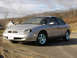 1999 Ford Taurus - This 1999 Ford Taurus is captured in a three-quarter front view, its silver exterior against a backdrop of trees and houses.