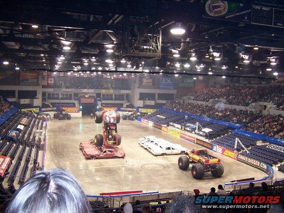 Monster truck arena with multiple trucks and crushed cars