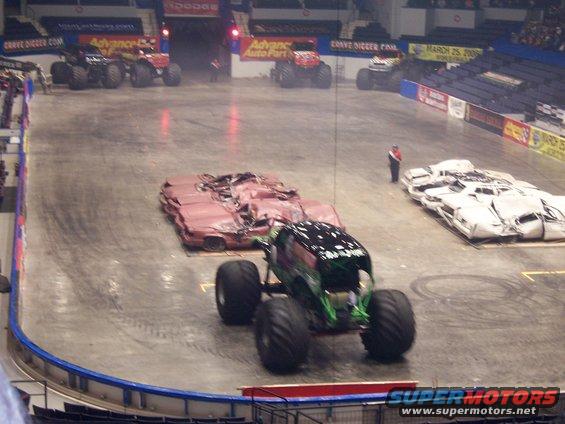 Monster truck in an arena with crushed cars lined up