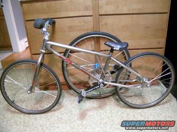 BMX bicycle with a second wheel behind it. Pedals show 'HARMONICS'