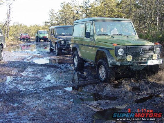 Green Mercedes-Benz G-Wagen on muddy trail, front view, license plate HX-UT 59