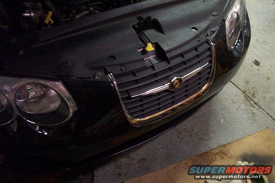 Black Chrysler grille with chrome trim and headlight