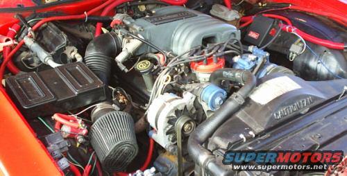 Engine bay with red hoses and a grey intake manifold
