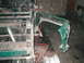 1983 Ford Bronco - Detail of a green fender flare and vehicle chassis, with visible damage and exposed metal components.