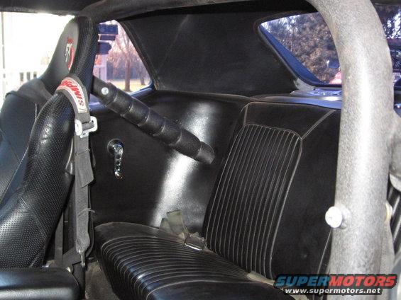 Interior view of a car with racing seats, roll cage, and Simpson racing harness