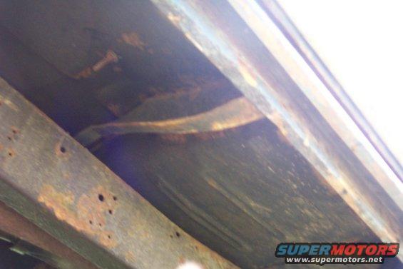 Underside of a rusty truck frame and suspension components