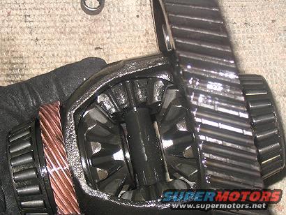 close-up of differential gears with a hand in a black glove holding them