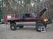 2001 Dodge 1500 - A lifted 2001 Dodge 1500 pickup truck is parked with its hood open, revealing the engine compartment.