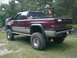 2001 Dodge 1500 - This lifted 2001 Dodge 1500 pickup truck features a two-tone paint scheme and a utility rack in the bed.