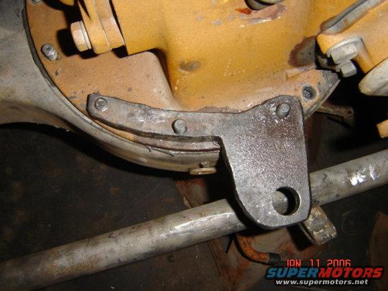close-up of a vehicle's rear differential housing with a metal bracket attached to a suspension bar