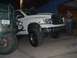 2001 Dodge 1500 - A white 2001 Dodge Ram 1500 pickup truck is parked next to another vehicle, showing its front 3/4 view with prominent off-road tires.