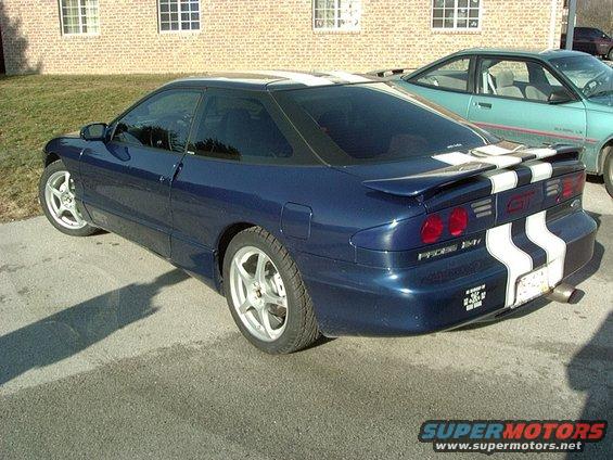 Blue 1995 Ford Probe GT with white racing stripes on rear and roof, parked next to a teal car