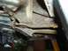 1985 Ford Bronco II - The underside of a vehicle shows significant rust and corrosion on its frame and suspension parts.