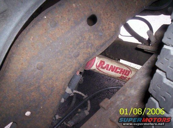 Rancho RS5000 shock absorber visible on rusty frame with leaf spring and tire tread