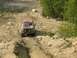 1995 Ford Bronco - Red 1995 Ford Bronco navigates a challenging off-road trail with a rocky terrain.