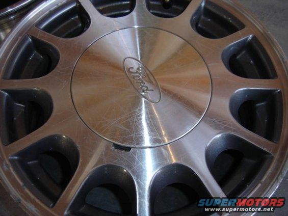 Close-up of a Ford wheel with scratches. The Ford logo is visible in the center